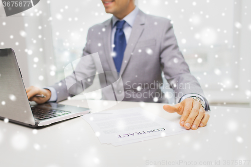 Image of close up of businessman with laptop and papers