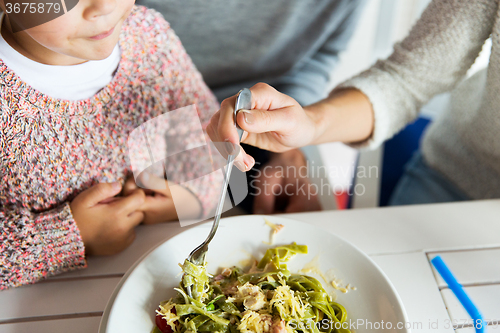 Image of close up of family having dinner at restaurant