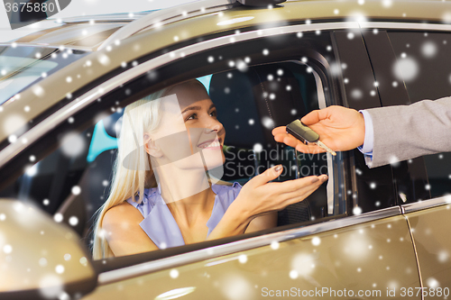 Image of happy woman getting car key in auto show or salon