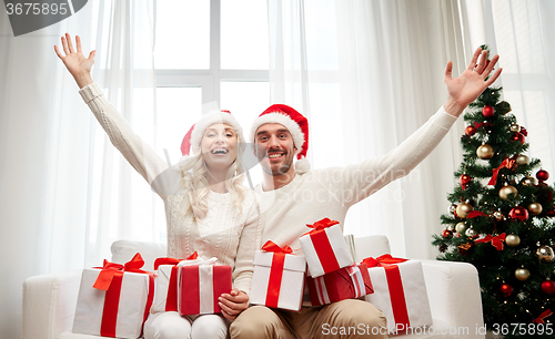 Image of happy couple at home with christmas gift boxes