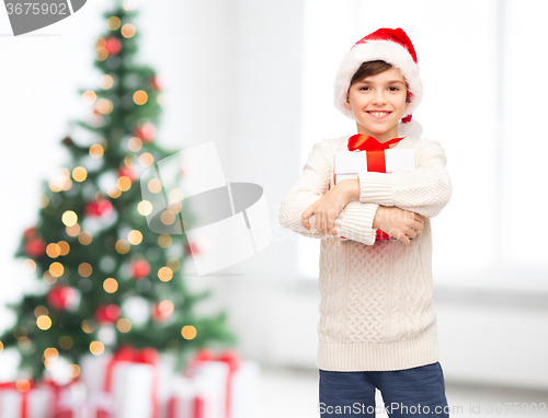 Image of smiling happy boy in santa hat with gift box