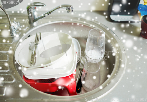 Image of close up of dirty dishes washing in kitchen sink