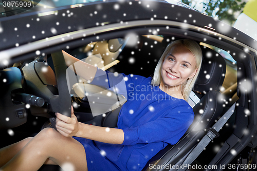 Image of happy woman inside car in auto show or salon