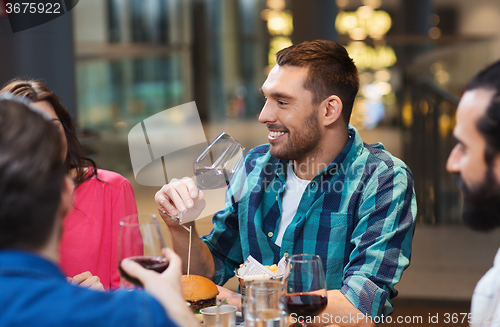 Image of friends dining and drinking wine at restaurant