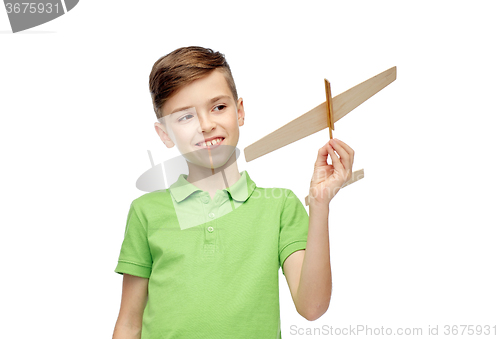 Image of happy boy in green polo t-shirt with toy airplane