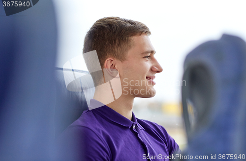 Image of happy young man sitting in travel bus