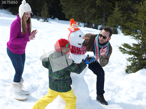 Image of happy family making snowman