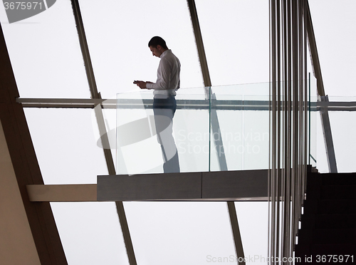 Image of young successful business man in penthouse apartment working on 