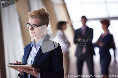Image of business woman  at office with tablet  in front  as team leader