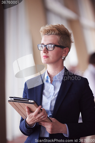 Image of business woman  at office with tablet  in front  as team leader
