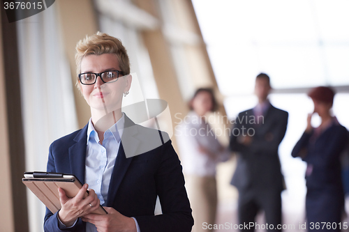 Image of business woman  at office with tablet  in front  as team leader