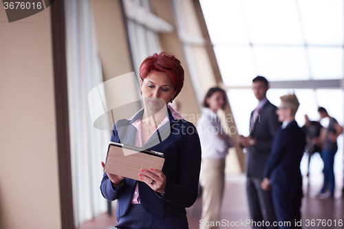 Image of business woman  at office with tablet  in front  as team leader