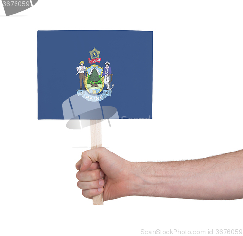 Image of Hand holding small card - Flag of Maine