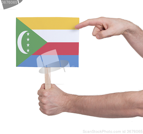 Image of Hand holding small card - Flag of Comoros