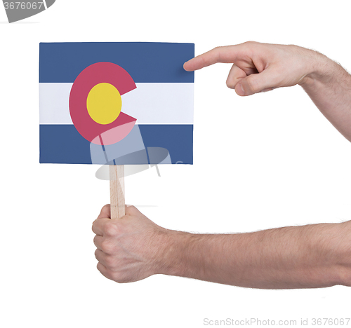 Image of Hand holding small card - Flag of Colorado