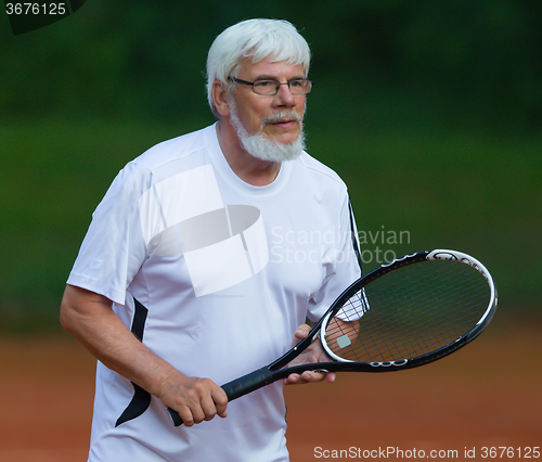 Image of Senior man playing tennis