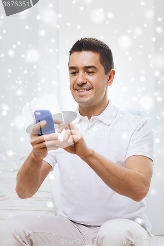 Image of happy man with smartphone at home