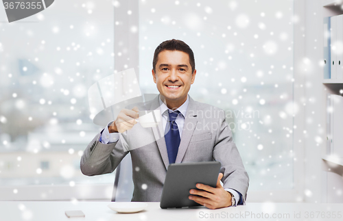 Image of smiling businessman with tablet pc and coffee cup