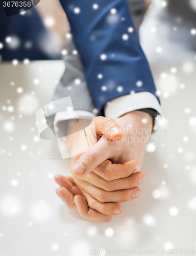 Image of close up of happy male gay couple holding hands