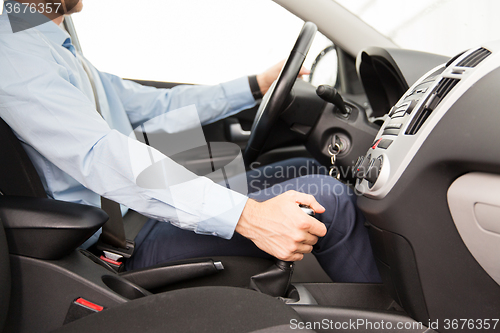 Image of close up of young man driving car