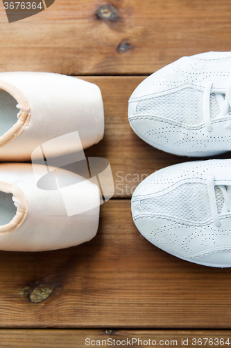 Image of close up of sneakers and pointe shoes on wood