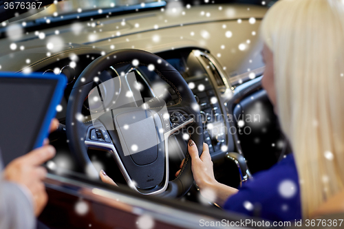 Image of woman and car dealer with tablet pc in auto salon