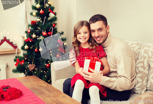 Image of smiling father and daughter holding gift box