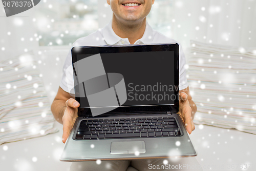 Image of close up of happy man showing laptop at home