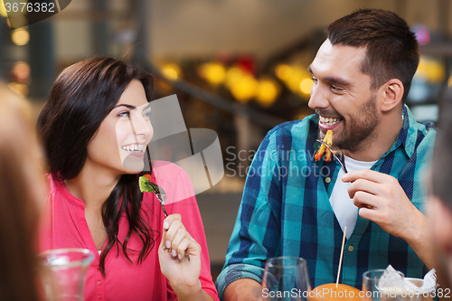 Image of happy friends having dinner at restaurant
