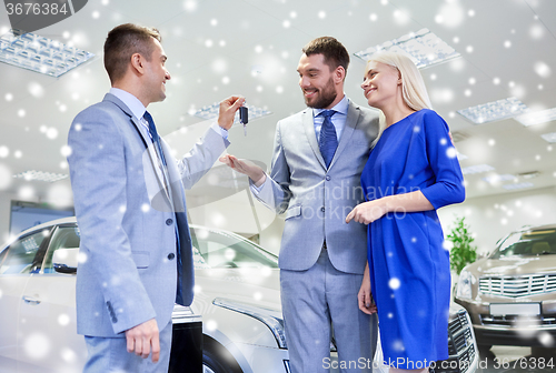 Image of happy couple with car dealer in auto show or salon