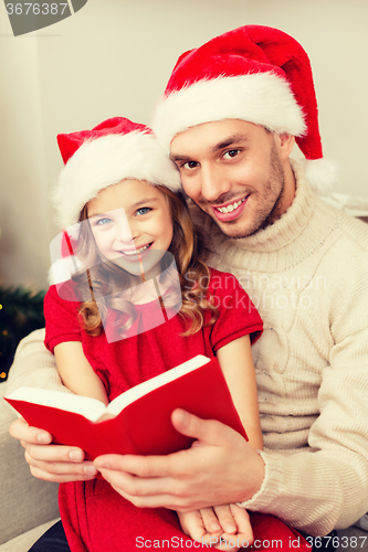 Image of smiling father and daughter reading book