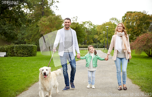 Image of happy family with labrador retriever dog in park