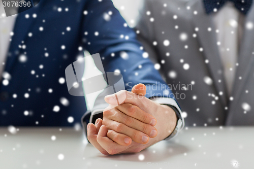 Image of close up of happy male gay couple holding hands