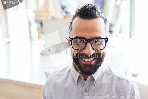 Image of smiling man with eyeglasses and beard at office