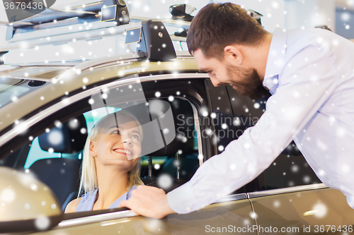 Image of happy couple buying car in auto show or salon