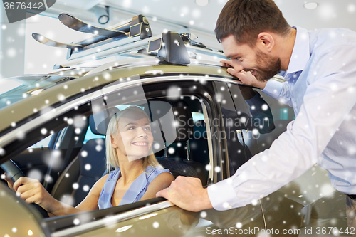 Image of happy couple buying car in auto show or salon