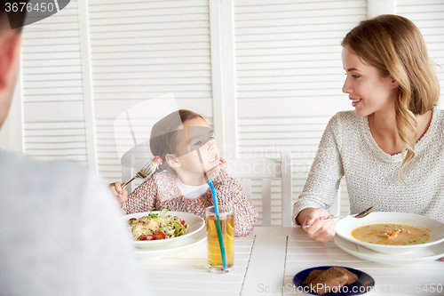 Image of happy family having dinner at restaurant or cafe