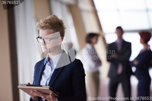 Image of business woman  at office with tablet  in front  as team leader