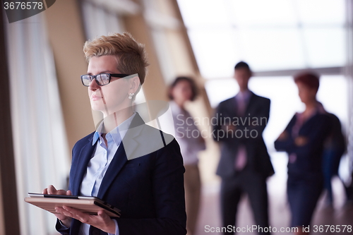 Image of business woman  at office with tablet  in front  as team leader