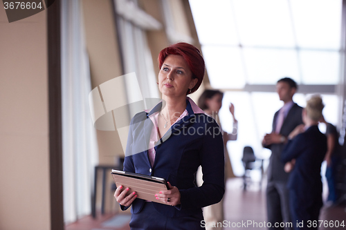 Image of business woman  at office with tablet  in front  as team leader