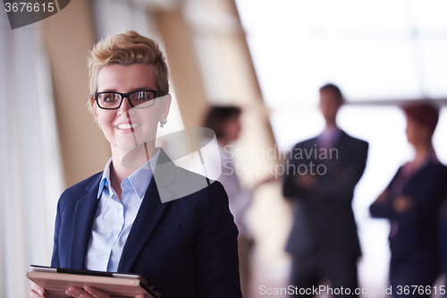 Image of business woman  at office with tablet  in front  as team leader