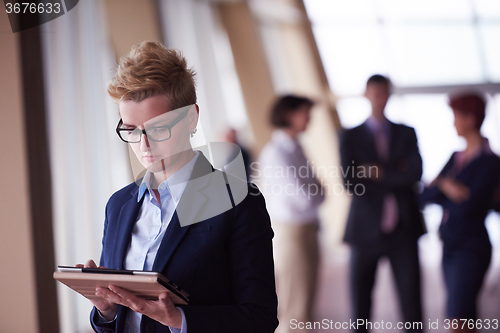 Image of business woman  at office with tablet  in front  as team leader