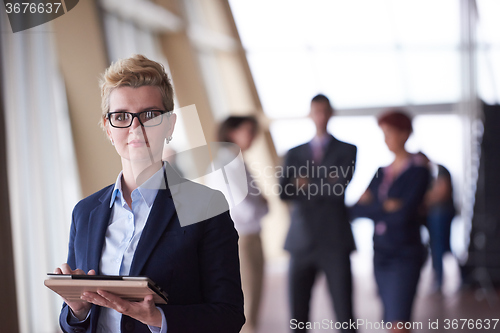 Image of business woman  at office with tablet  in front  as team leader