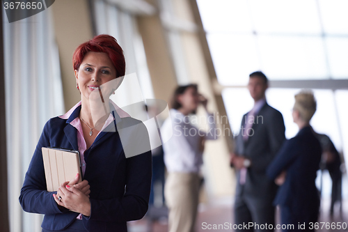 Image of business woman  at office with tablet  in front  as team leader