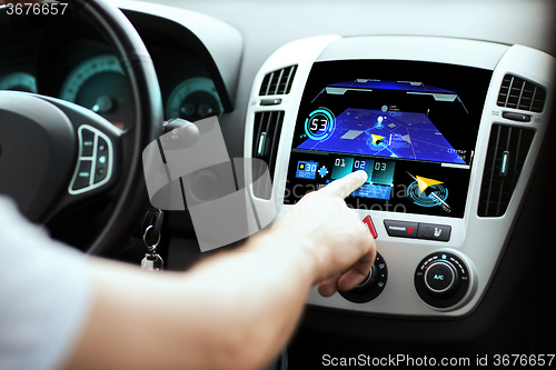 Image of male hand using navigation system on car dashboard