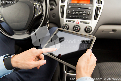 Image of close up of young man with tablet pc driving car