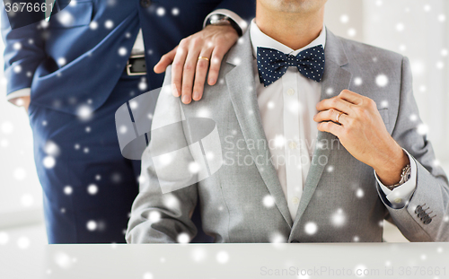 Image of close up of male gay couple with wedding rings on