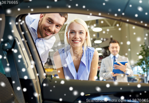 Image of happy couple with car dealer in auto show or salon