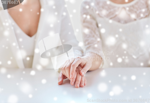 Image of close up of happy married lesbian couple hands