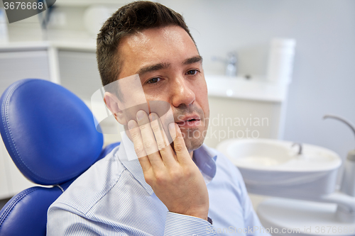 Image of man having toothache and sitting on dental chair